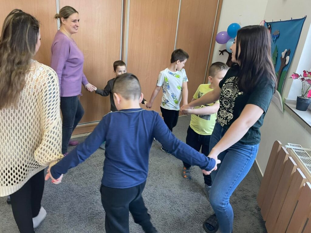 Dzieci z nauczycielami tańczą w kręgu