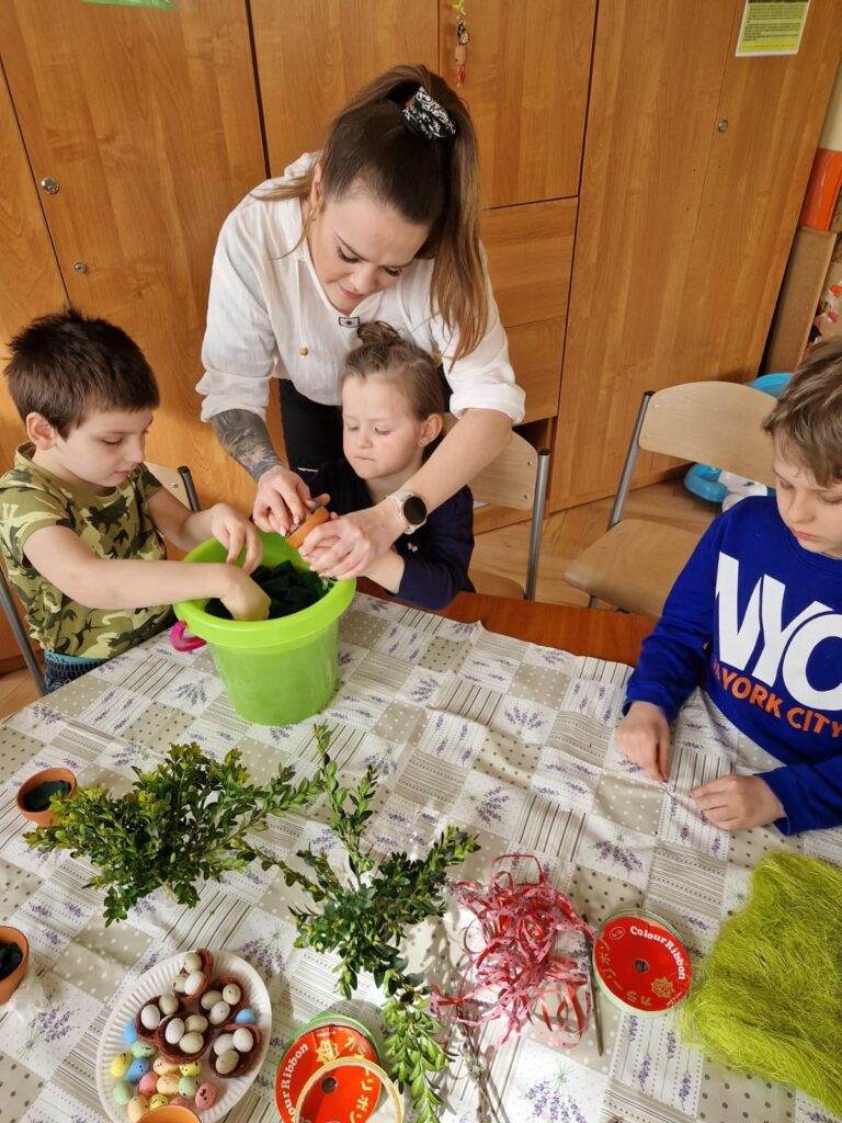 Dzieci wypełniają gąbką florystyczną doniczki